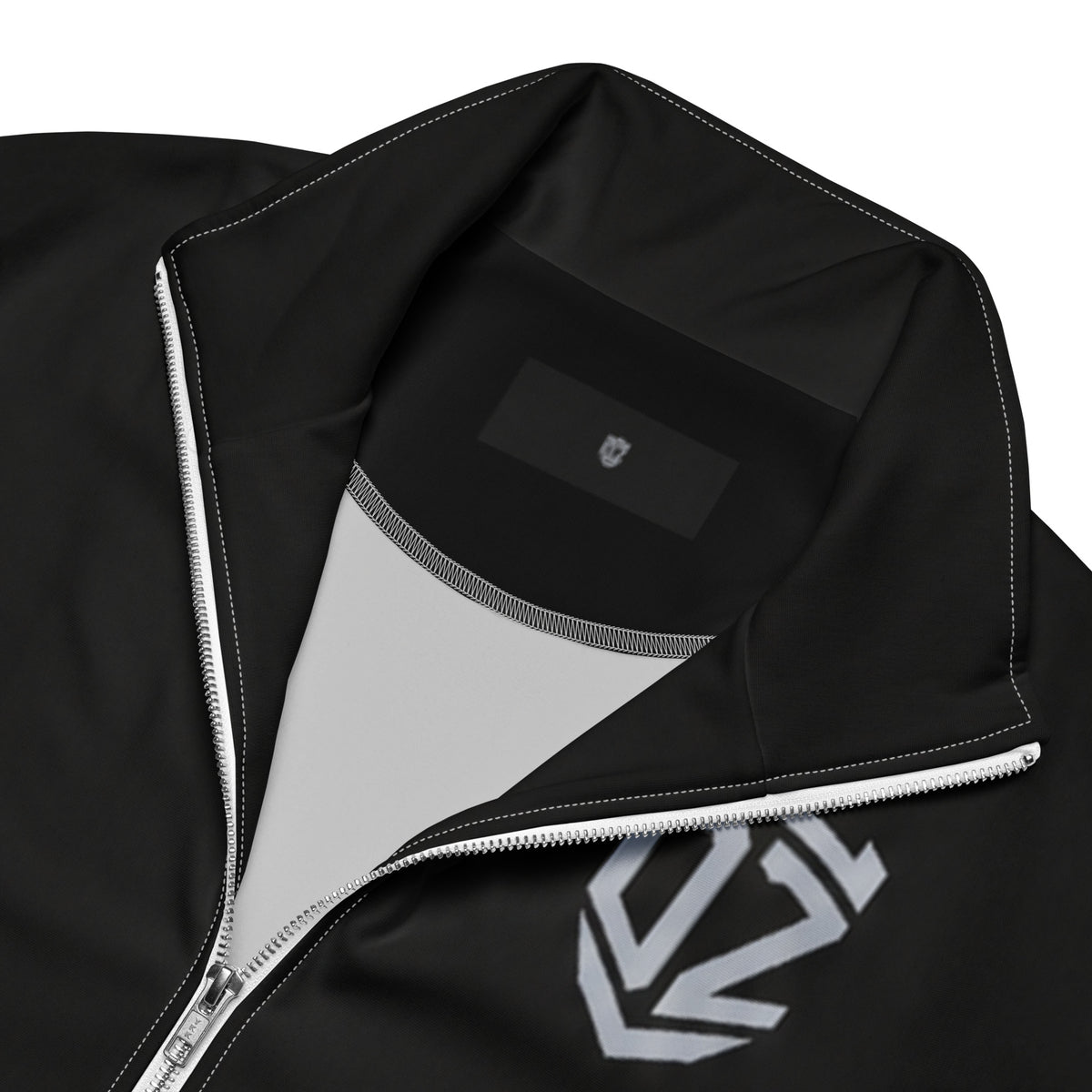 Détail de la fermeture zippée et du tissu recyclé de la veste de survêtement